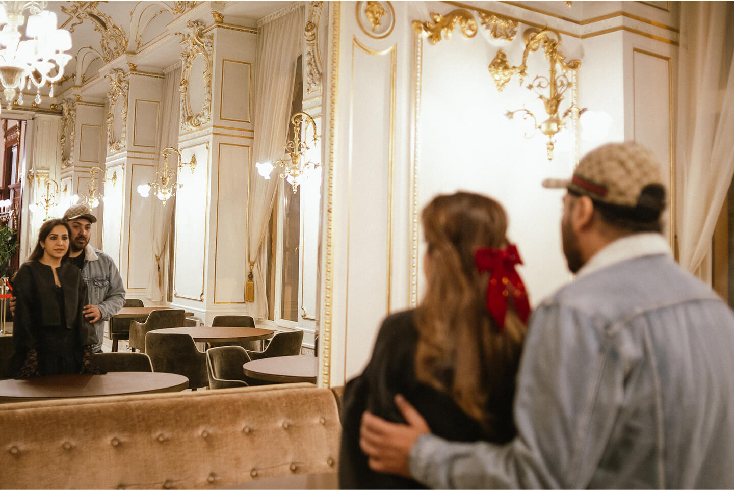 Pár tükörbe nézve áll egy elegáns kávéház belső terében