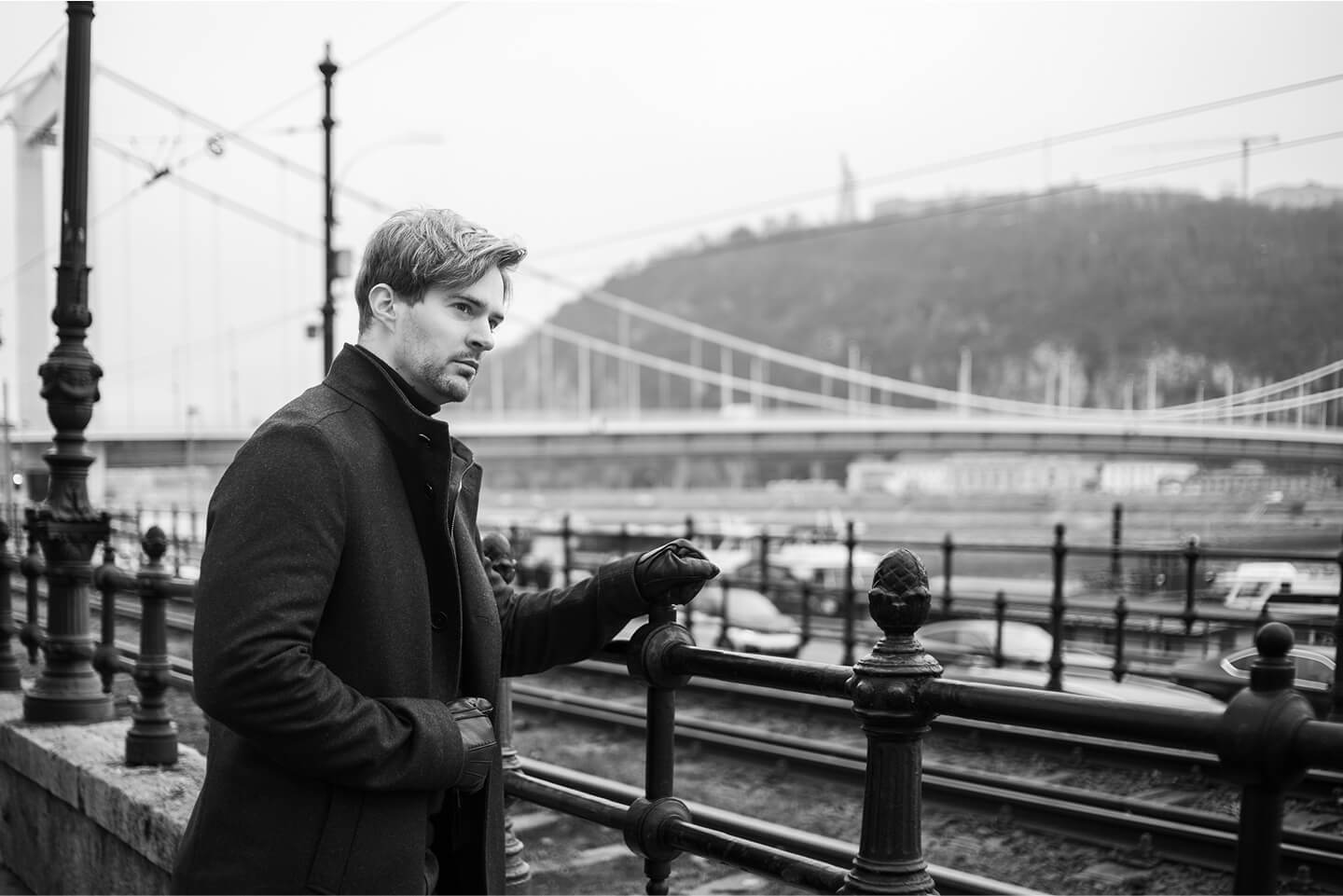 Fekete-fehér férfi portré városi háttérrel és híddal